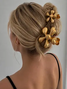 Detailed view of two gold flower hair claws for women styled on the back of the head