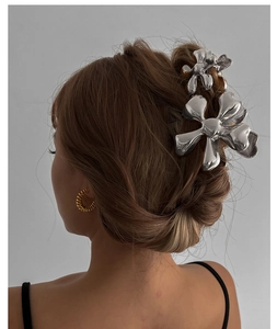 Detail of silver metallic flower hair clips showing shiny texture and elegant styling