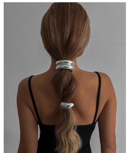 Vue arrière du mannequin portant trois anneaux de cheveux en métal liquide sur queue