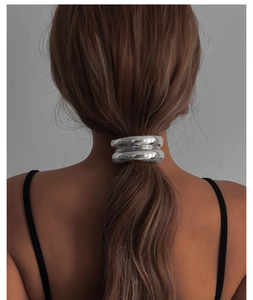 Accessoire cheveux en métal argenté poli porté sur une coiffure queue de cheval