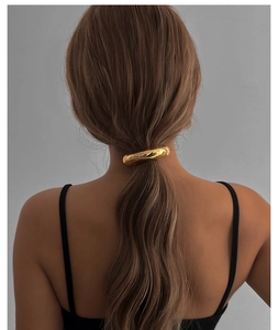 Rear view of a model wearing a high-shine golden geometric metal ring ponytail holder hair tie