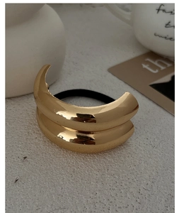 Close-up of a minimalist gold alloy double-ring hair tie with high elastic band