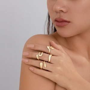 Macro detail of irregular gold geometric ring set with polished fluid line shapes