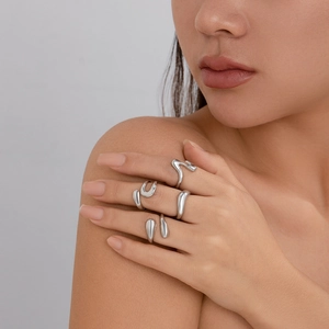 Set of five irregular liquid metal rings in polished silver worn by a model