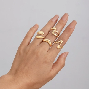 Detailed view of layered irregular gold rings featuring minimalist liquid metal design