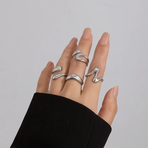 Detail of irregular silver liquid metal rings with a polished finish on model hand