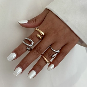 Detail of minimalist wave rings in gold and silver finish worn on fingers