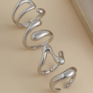 Macro detail of silver fluid irregular geometric rings with a polished mirror finish