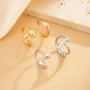 Detailed view of irregular fluid geometric rings in gold and silver on textured stone