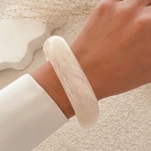 Minimalist wide ivory white resin bangle with marble texture worn on wrist