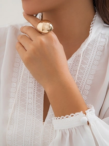 Close-up of a large chunky golden dome ring with a high-polished mirror finish