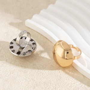 Macro detail of adjustable chunky dome rings in gold and silver polished metal finish