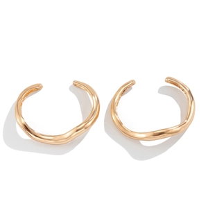 Detailopname van gepolijste onregelmatige golvende gouden armband met metaaltextuur