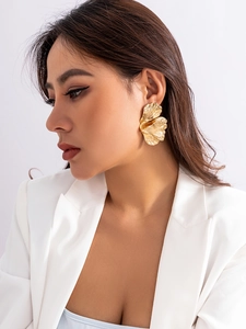 Nahaufnahme unregelmäßiger goldener Ohrringe an einem Model im Modestil
