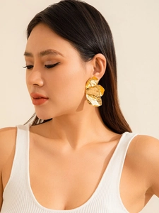 Nahaufnahme von Model mit goldfarbenen gehämmerten Metallohrringen im strukturierten Design