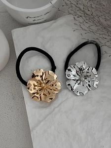 Close-up of gold and silver metallic flower hair ties with hammered petal texture