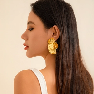 Goldene unregelmäßige hohle Blumen-Ohrstecker in einem minimalistischen geometrischen Design