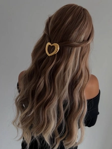 Pince à cheveux minimaliste en forme de cœur doré ajouré sur cheveux blonds ondulés