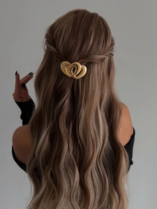 Pince à cheveux double cœur doré sur cheveux longs bouclés pour une coiffure élégante