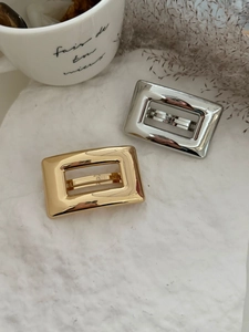 Détail de pinces à cheveux rectangulaires évidées en or et argent sur pierre