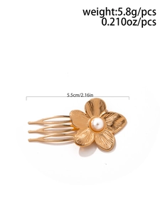 Detailed view of golden flower hair pin with faux pearl and engraved petal texture