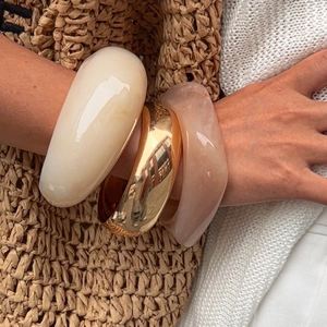 Three-piece set of chunky resin and gold metal bracelets with marble texture and ivory finish