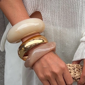 Geometric chunky bangle set in cream, gold, and amber resin on a model's wrist