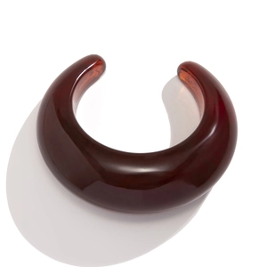 Macro detail of high-quality amber resin open bangle with minimalist curved texture