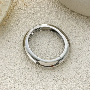 Macro detail of silver geometric bangle featuring a hinge closure and polished finish