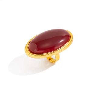Vintage oversized gold ring featuring a large oval red resin stone on a white background