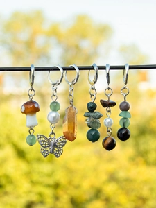 Macro view of bohemian tassel charms with natural stones and metal butterfly pendants