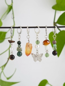 Detailed close-up of bohemian hair charms with butterfly pendants and raw stone beads