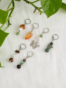 Detailed view of handmade earrings with natural stones, mushroom beads, and silver charms