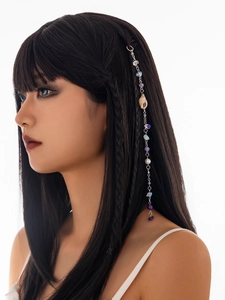 Detail of beach hair chain with seashells, natural stones, and silver tassels on hair