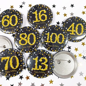 Detail of 58mm black and gold birthday badges with glitter numbers and safety pin back