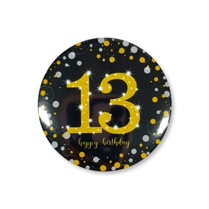Macro shot of 58mm black and gold 13th happy birthday badge with glitter texture