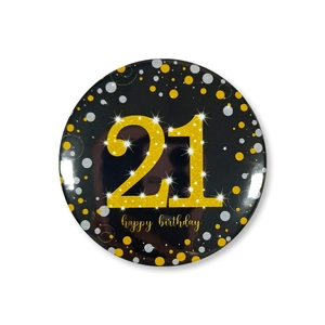 Close-up of a 58mm black and gold 21st birthday badge with glitter number and dots