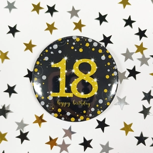 Detail of 58mm black and gold 18th birthday badge with glitter number and happy birthday text