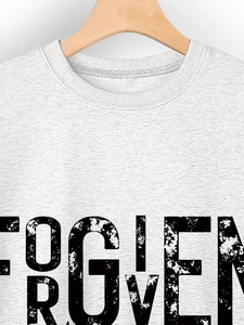 Detail of white cotton sweatshirt featuring a distressed FORGIVEN print and ribbed neckline
