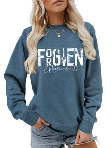 Detail of vintage-style white FORGIVEN lettering on a dusty blue cotton crewneck sweatshirt