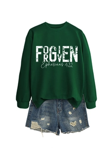 Close-up of FORGIVEN print on dark green crewneck sweatshirt and distressed denim shorts