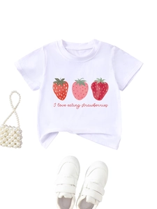Détail à plat d'un t-shirt blanc en coton avec fraises, chaussures et sac à perles