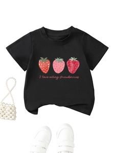 Détail d'un t-shirt enfant noir avec imprimé fraise et accessoire sac en perles