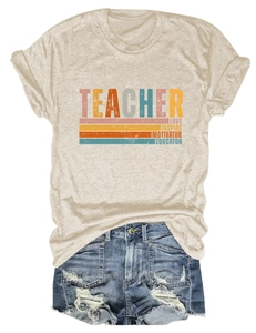 Détail à plat d'un t-shirt beige avec imprimé rétro TEACHER LOVE INSPIRE et jean usé