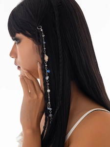 Detail of silver hair chain with white seashells and blue beads on a model braid