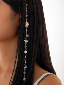 Bohemian hair chain detail with seashells and natural stones on a braided hairstyle