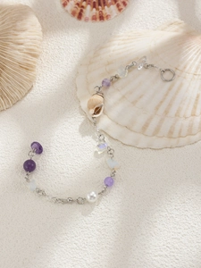 Detail of seashell and purple crystal bead tassel hair chain with metallic finish