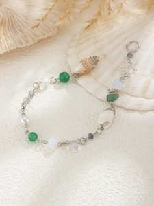 Detailed view of bohemian seashell charms and natural beads on a silver metal chain