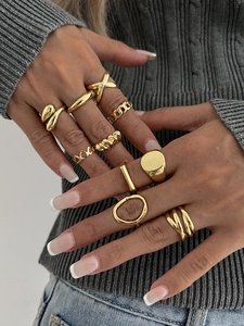 Close-up of 10-piece gold ring set featuring geometric patterns and polished finish