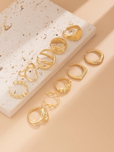 Close-up of a 10-piece gold geometric ring set with textured and hollow patterns